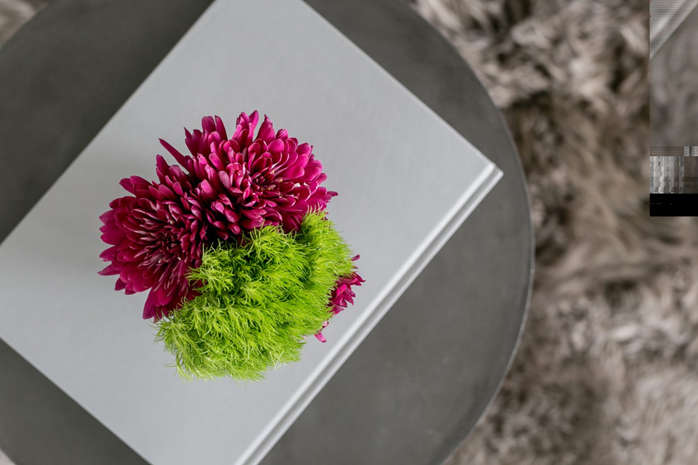 Pink And Green Flowers In Vase On Coffee Table Book